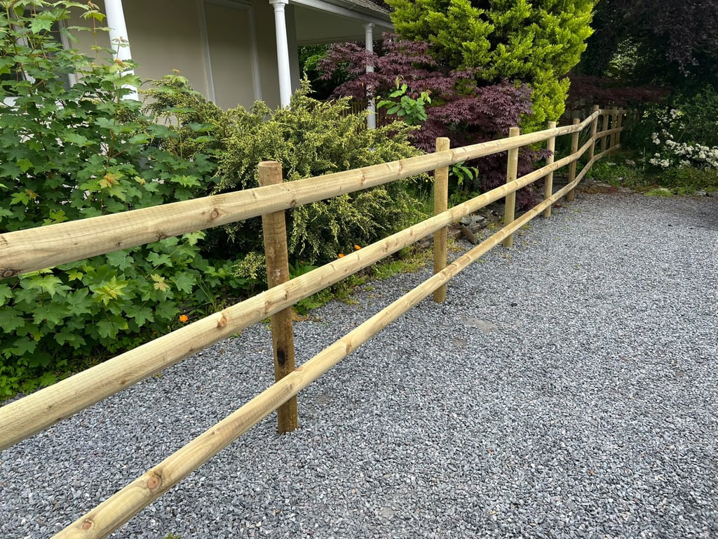 New timber post and rail fencing installed by PC Landscaping alongside a gravel drive in South Devon
