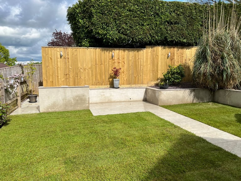 Rendered garden walls and raised beds built by PC Landscaping around a paved seating area in South Devon
