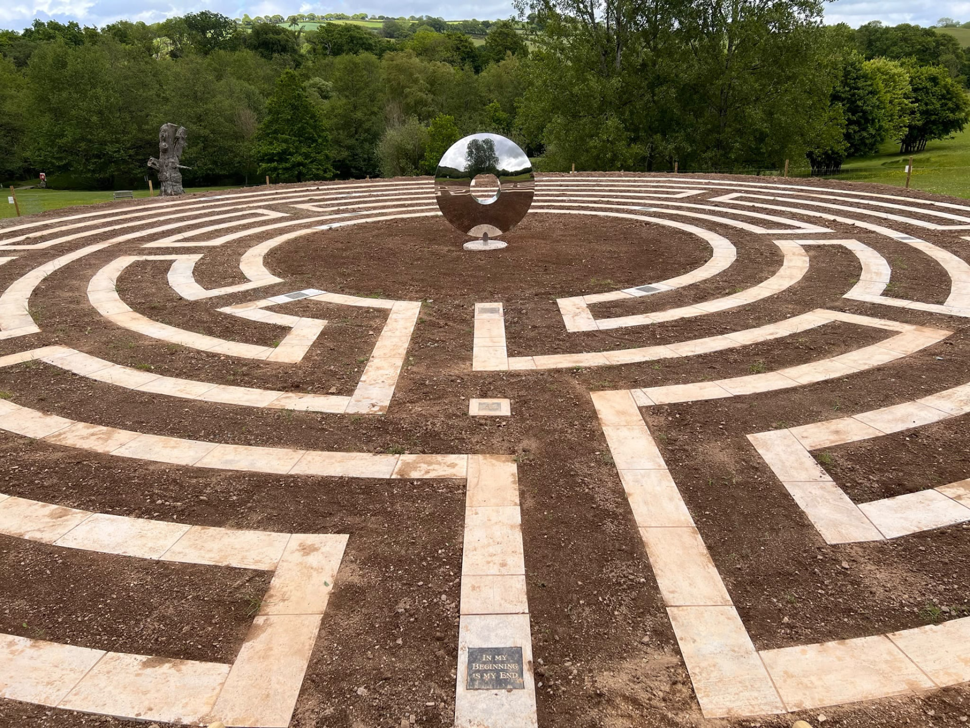 Stone-paved circular labyrinth path built into a Devon hillside